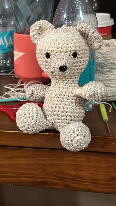 Adorable crochet teddy bear plush, made from soft yarn, perfect for cuddles and companionship for children.